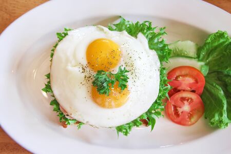 Tasty fried eggs on toast bread bacon in sandwich breakfast with fresh organic lettuce , tomatoes...