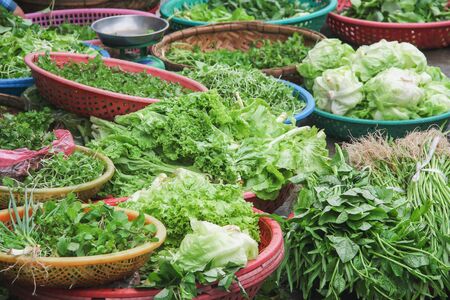 Fresh organic vegetables in multicolored basket for sale in local market, Vietnam
