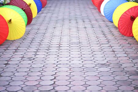 Concrete block stone walkway and decoration colorful multicolored umbrella on the side backgroundの写真素材