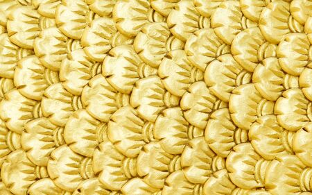 Bright gold serpent scale statue patterns or colorful yellow naga texture abstract for background