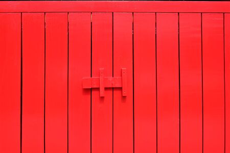 Red wood door with latch colorful texture abstract for backgroundの写真素材
