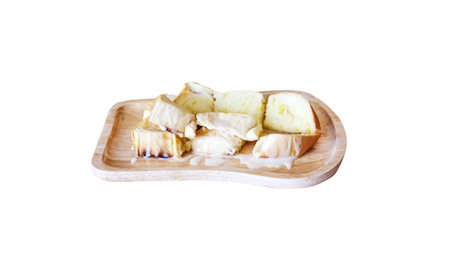 Bread toast with sweet condensed milk on wood plate isolated on white background , clipping pathの写真素材