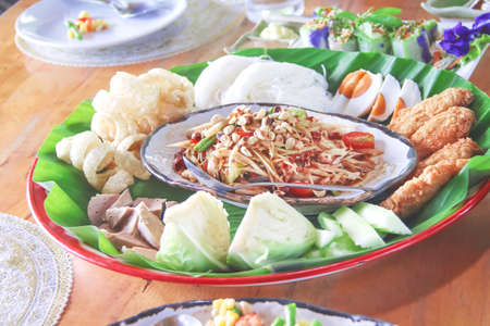 Spicy papaya salad with bean,egg , thai rice flour noodles, pork snack, in tray ,Thai food backgroundの写真素材