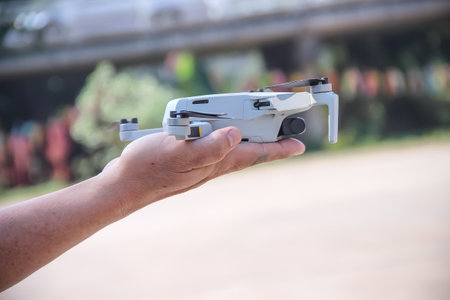 Asian man hand holding drone on white sky backgroundの写真素材
