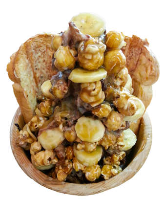 A favorite dessert in summer at Thailand, Fantasy ice with bread banana popcorn caramel cocoa flavored ice on white backgroundの写真素材