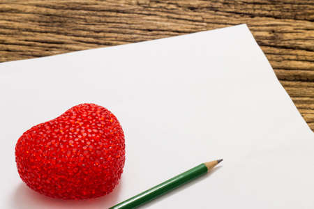 Red heart and paper on wooden backgroundの写真素材