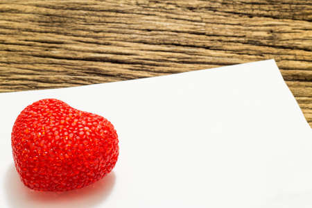 Red heart and paper on wooden backgroundの写真素材