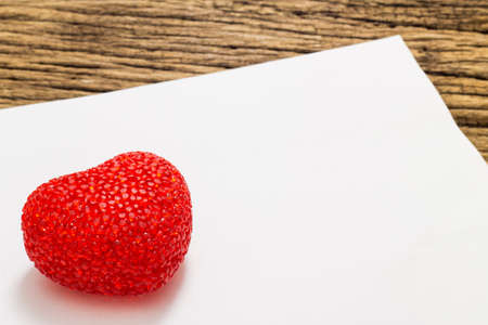 Red heart and paper on wooden backgroundの写真素材