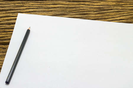 Blank sheet of paper and pencil on old wooden background.の写真素材