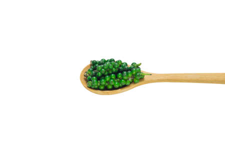 Green pepper in wooden spoon isolated on white background.の写真素材