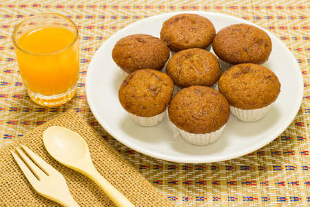 Banana cup cake and orange juice on bamboo mat.の写真素材
