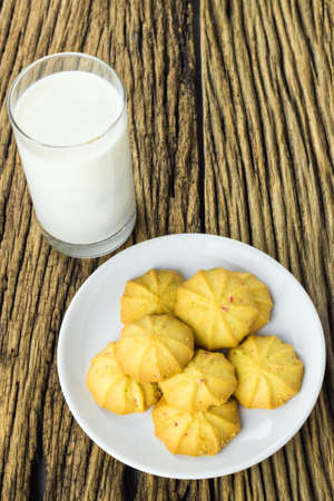 Cookies in dish with a glass of cold milk on wooden background.の写真素材