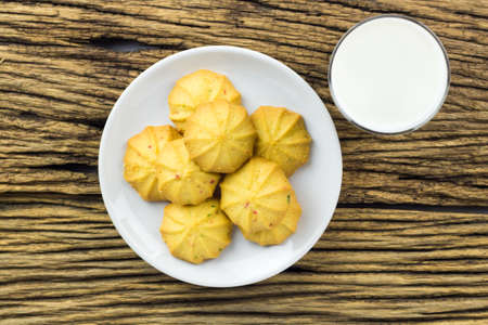 Overhead cookies in dish with a glass of cold milk on wooden background.の写真素材