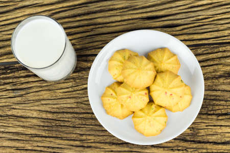 Overhead cookies in dish with a glass of cold milk on wooden background.の写真素材