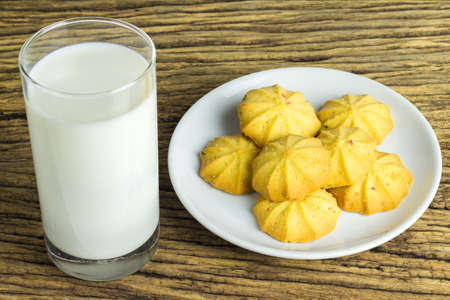Cookies in dish with a glass of cold milk on wooden background.の写真素材