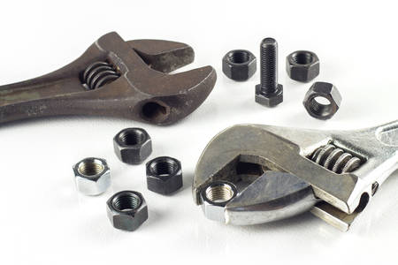 Metal wrench with nuts and bolts on white.の写真素材