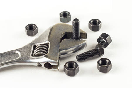 Metal wrench with nuts and bolts on white.の写真素材