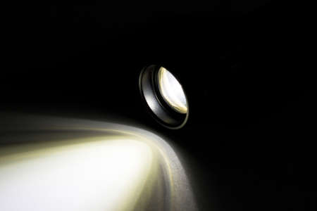 LED flashlight with a light beam at night.