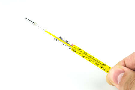 Thermometer in a hand isolated on white background. Temperature measuring.の写真素材
