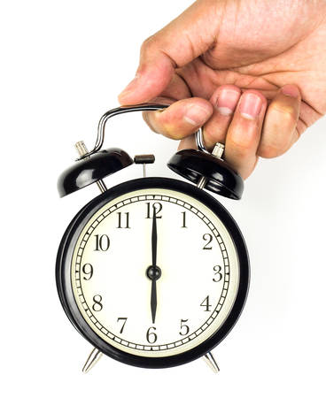 Hand holding a clock, on a white background.の写真素材
