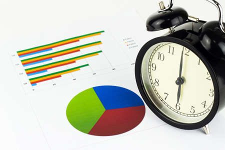 Analyzing graphics, calculations, savings with alarm clock.の写真素材