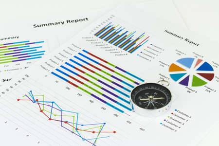 Bussiness graphs and finances with a compass lying nearby.の写真素材
