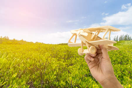 Toy airplane in hand - a symbol of travel and dreams.の写真素材