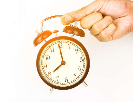 Man's Hand holding a alarm clock.