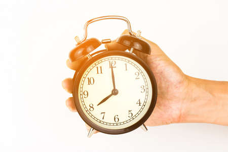 Man's Hand holding a alarm clock.の写真素材