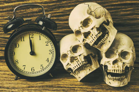 Skulls and clock on wooden backgroundの写真素材