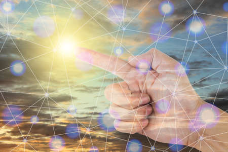 Double exposure of hand pointing the net, with the sky background.の写真素材