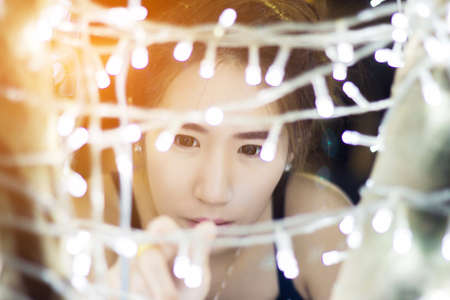 Close up young cute and beautiful asian girl with bokeh light on background.