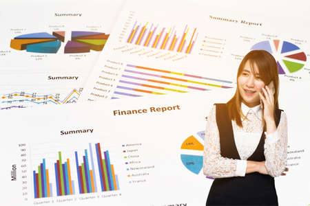 Young Asian Business woman smile talking with Graph Calculations, savings, finances and economy concept.の写真素材
