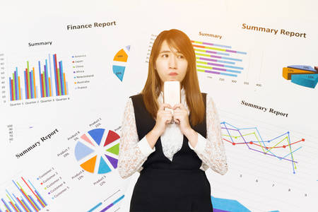 Young Asian business woman thinking with Graph Calculations, savings, finances and economy concept.の写真素材