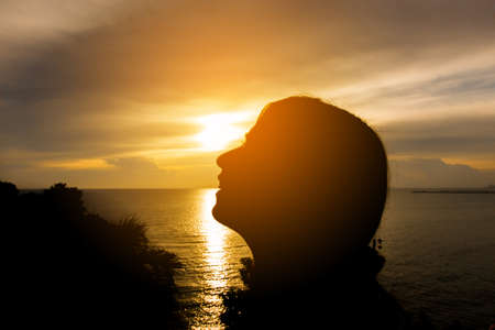 Silhouette of the woman smile at the beach during beautiful sunset.の写真素材