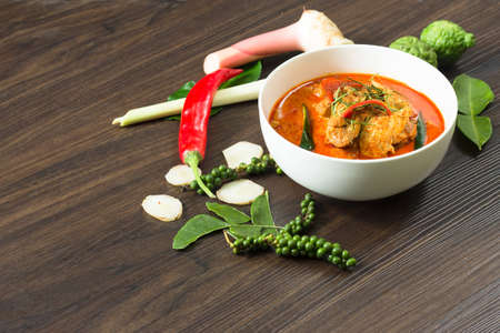 Panaeng Curry with Pork with spices, chili, lemon grass,bergamot leaf on wooden background.の写真素材