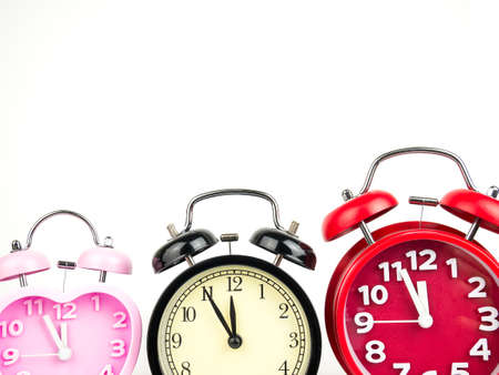 Three alarm clock, red, pink, black isolated on white background.の写真素材