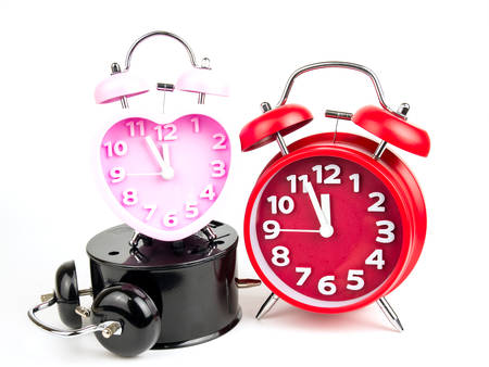 Three alarm clock, red, pink, black isolated on white background.の写真素材