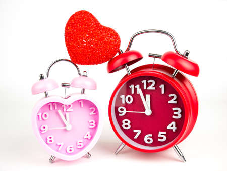 Red and Pink alarm clock in the form of heart isolated on white background, Valentine's Day.の写真素材