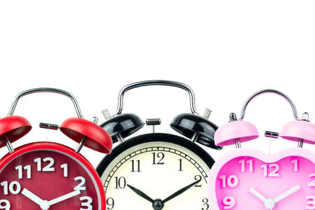 Three alarm clock, red, pink, black isolated on white background.の写真素材