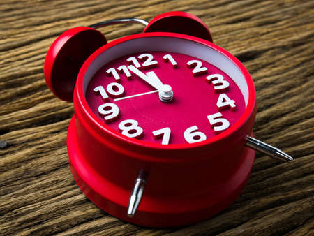 Red alarm clock on wooden background.の写真素材