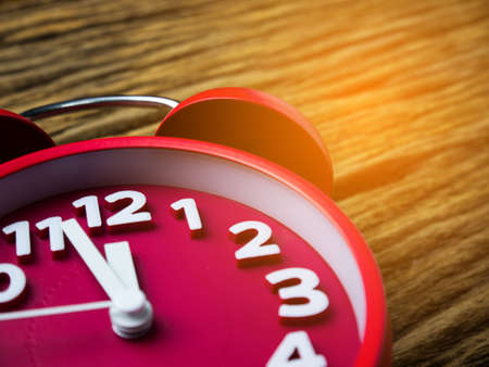 Red alarm clock on wooden background.の写真素材