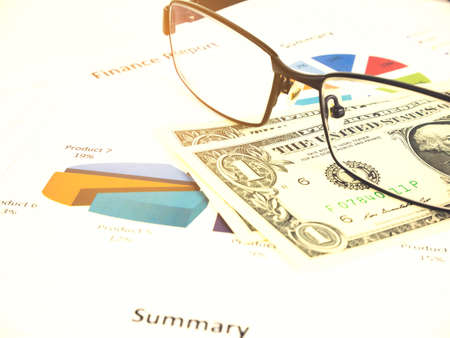 Business chart near dollars by unfocused glasses, Financial concept.の写真素材