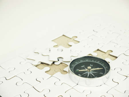 Compass on jigsaw puzzle background, business concept.の写真素材