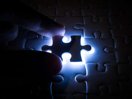Missing Jigsaw puzzle piece with lighting, business concept for completing the finishing puzzle piece.の写真素材