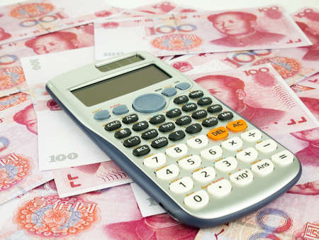 It is a lot of One hundred Yuan banknotes pile as background with Calculator, Chinese yuan Currencies.の写真素材
