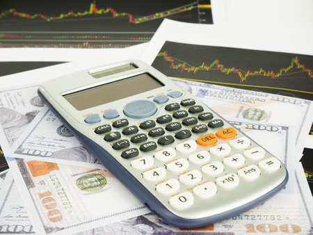 Calculator with business graphs and report information background for financial and economy concepts.の写真素材
