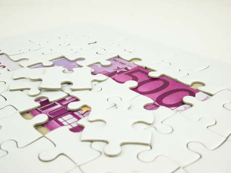 Missing jigsaw puzzle pieces on Five hundred 500 Euro bills banknotes background, Business solution concept, Key for success concept.の写真素材