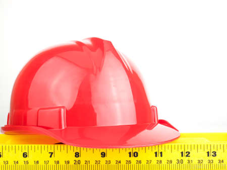 Red safety helmet and Balance ruler on white background, Engineering construction concept.の写真素材