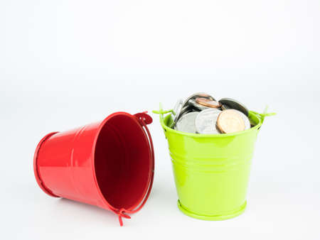 Money coins in green bucket on white background, Business concept.の写真素材